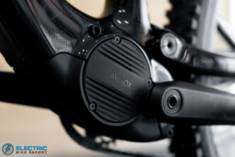 Close-up of a black electric bike motor/crank with the AVNOX logo visible on the circular cover.