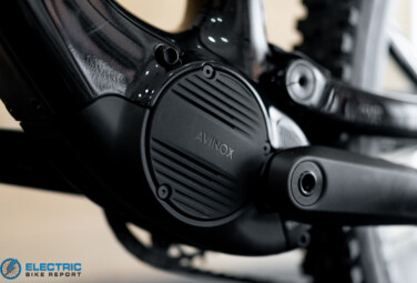 Close-up of a black electric bike motor/crank with the AVNOX logo visible on the circular cover.