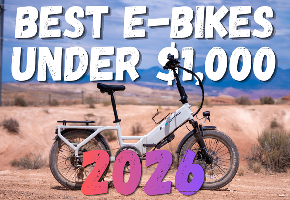 Electric white e-bike in a desert landscape with bold overlay text: 'Best E-Bikes Under $1,000 2026'