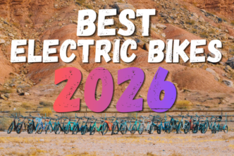 Banner reading "Best Electric Bikes 2026" with colorful 2026 typography above a row of electric bikes parked in a desert landscape.