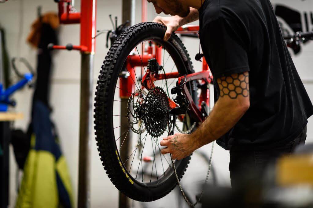 Bike mechanic assembling an electric bike at The Pros Closet workshop