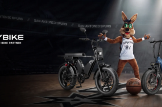 Promotional banner: two Heybike electric bikes on a basketball court with a Spurs mascot in a jersey under spotlights.